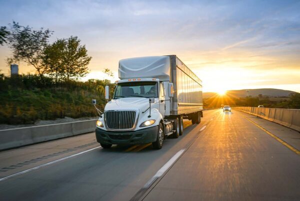 Inland Marine Insurance - White Semi-truck Transporting Cargo on the Highway and Delivering Freight across Country at Sunset